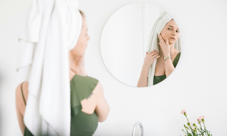 Uses of argan oil: Woman in front of a mirror