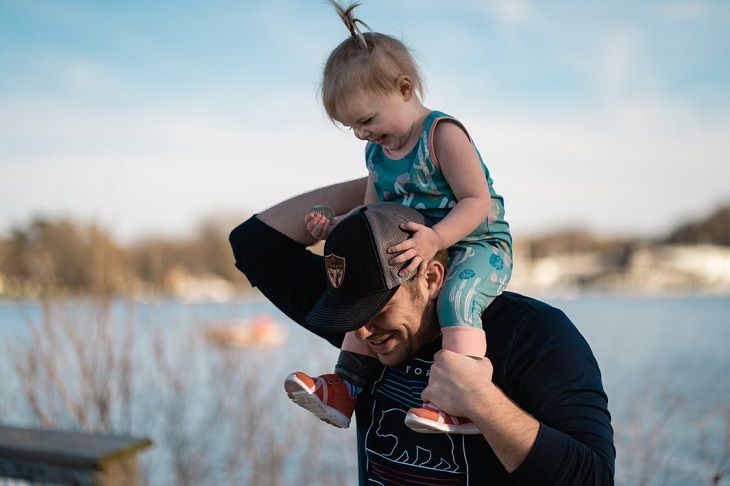 Small parental gestures for children: A father carrying his daughter on his shoulders, both smiling